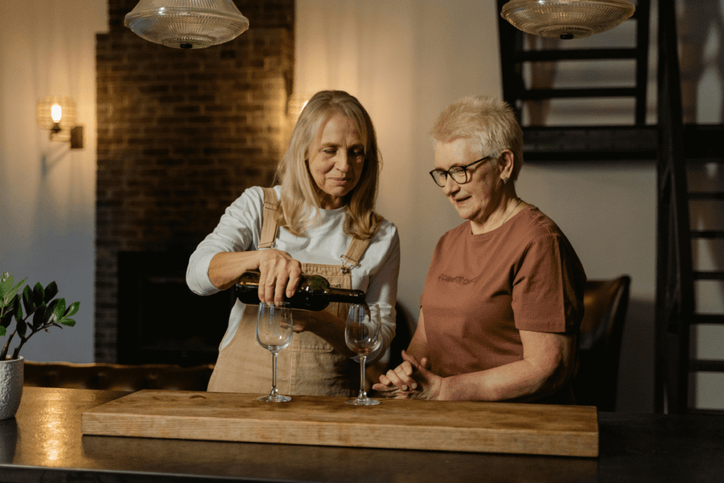 Mulher de meia-idade e sua mãe tomando vinho.