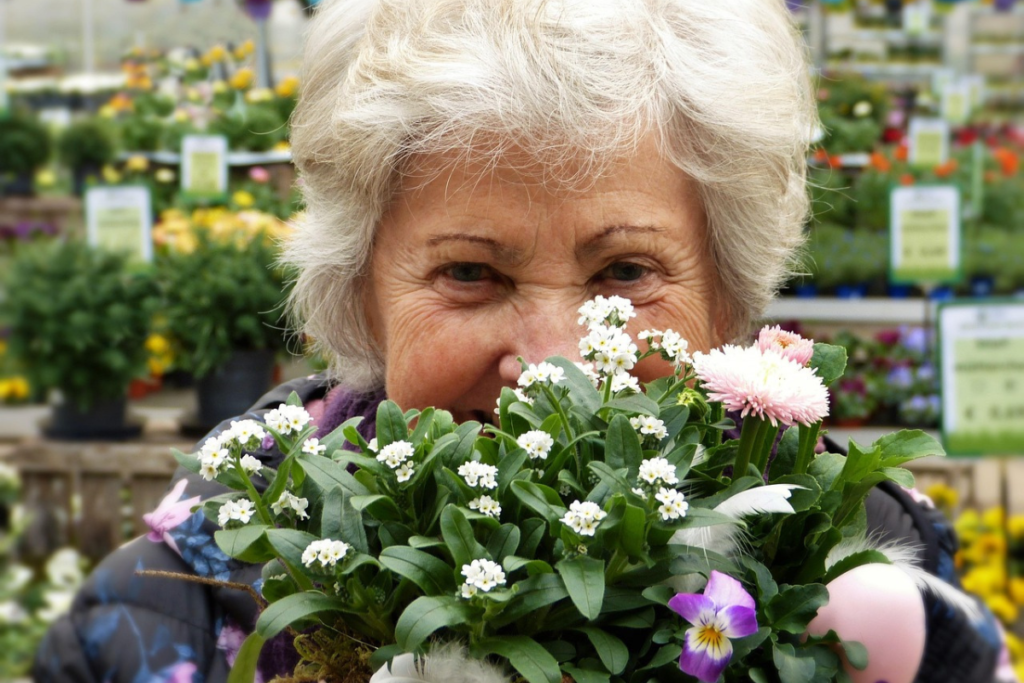 Idosa feliz con buquet de flores.