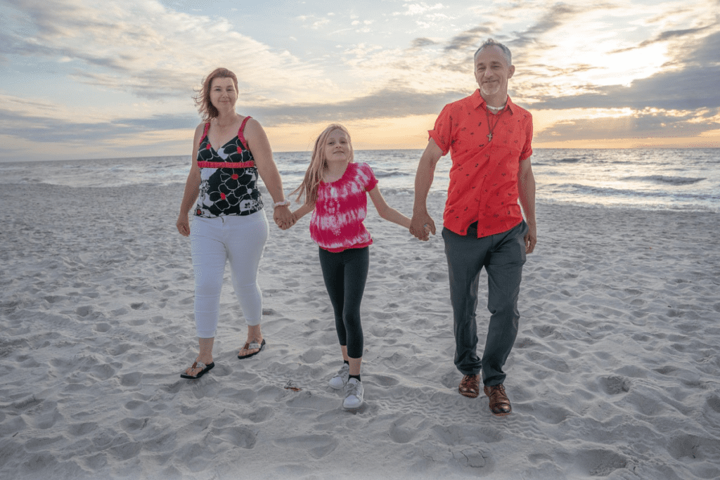 Família caminhando na praia.