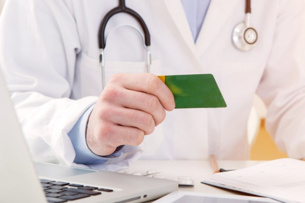 Médico entregando carterinha do plano de saude.